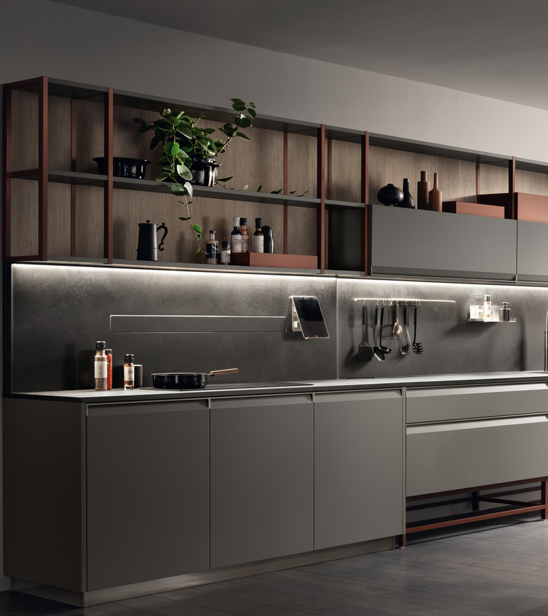 Modern kitchen with sleek cabinetry, a dining table, and a large window featuring greenery. Stylish and minimalistic design.